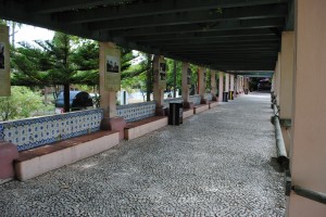 A long stretch of Portuguese pavement under a pergola