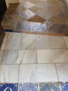 transition from marble with glazed tile pattern, over flagstones surround, to chequer: flagstone/cobbles in concrete